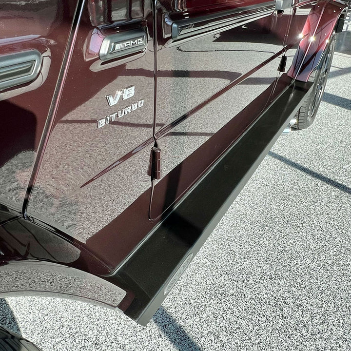 Side profile of the G-Class with both driver and passenger step sliders installed, showcasing a balanced, luxury look.