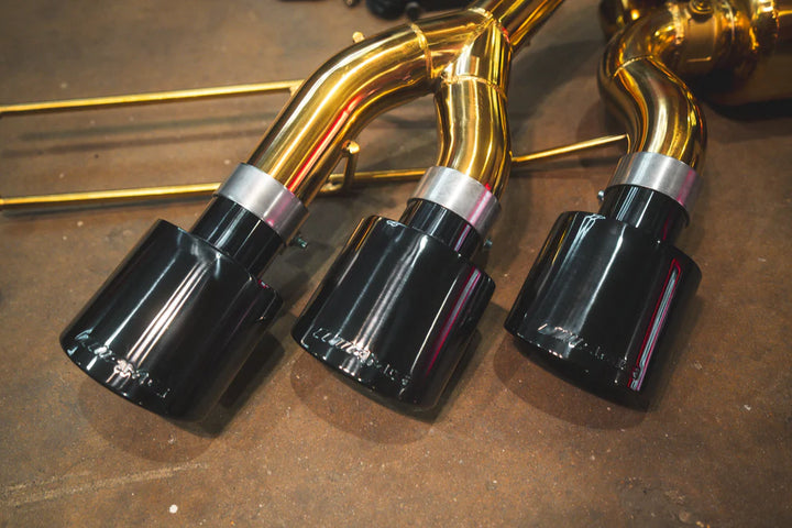 Valvetronic exhaust system on parked Mercedes-AMG G63, highlighting quad-tip design and carbon fiber diffuser