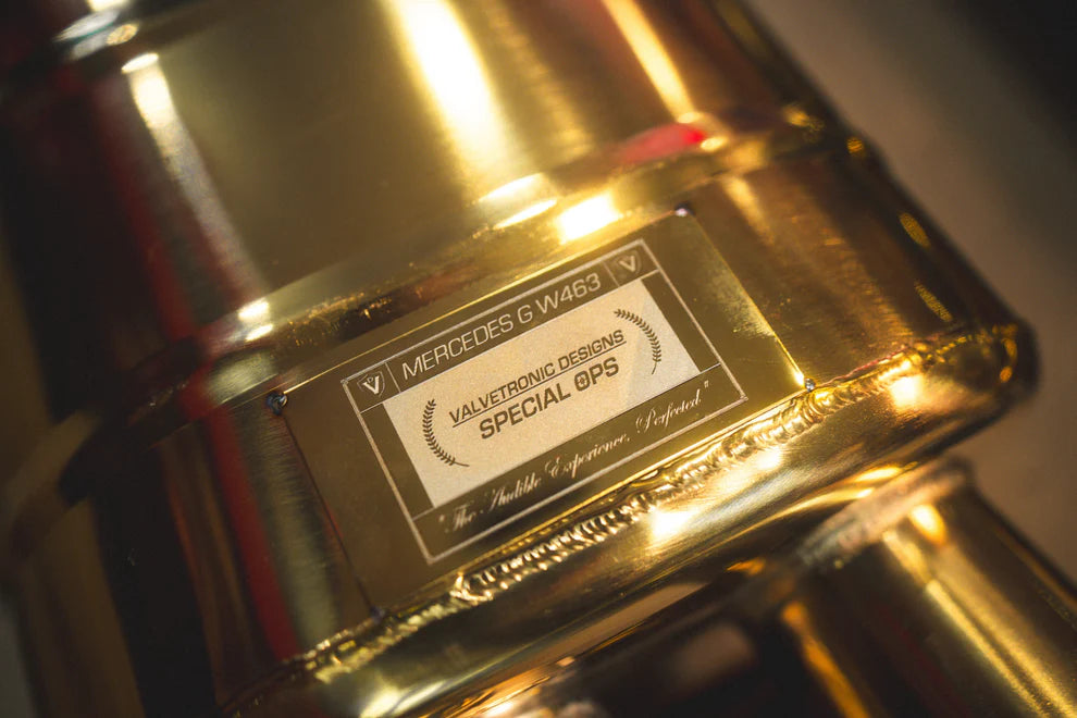 Close-up of Valvetronic exhaust's black ceramic tips with laser-etched branding on Mercedes G-Wagon