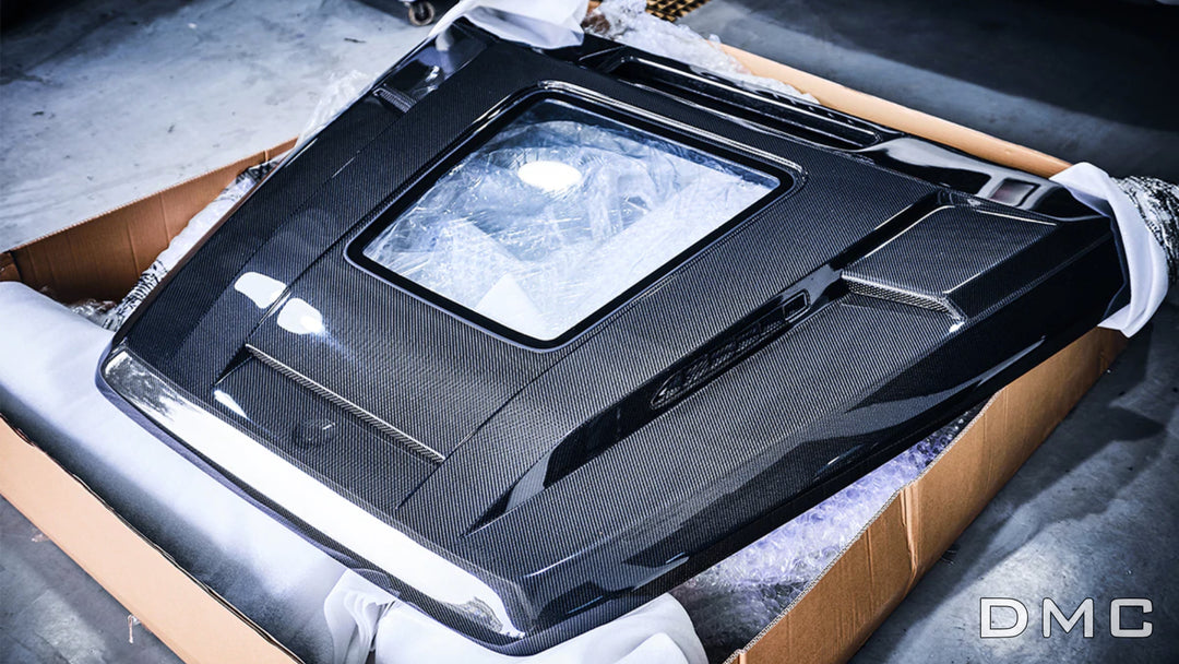 Polished aluminum-framed glass window on DMC carbon hood – showcases AMG engine bay