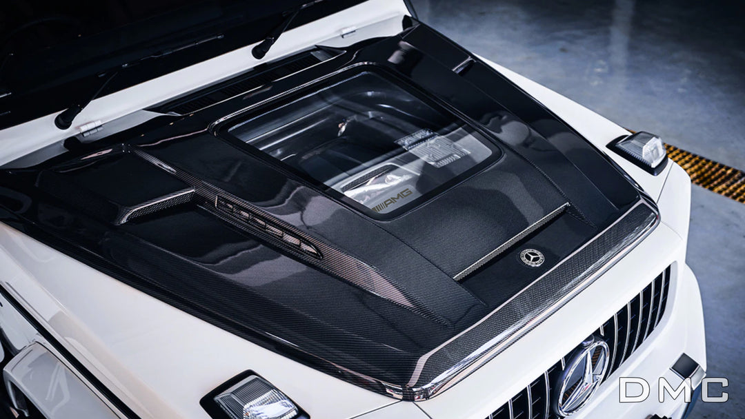 MC forged carbon fiber hood with glass window for Mercedes-AMG G63 (W463A) – marbled weave with gloss finish installed on white AMG G63