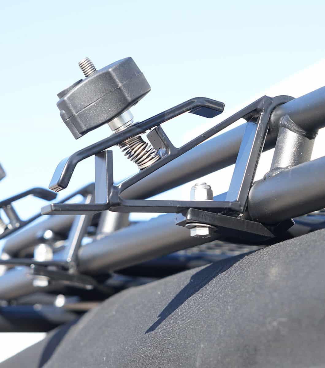 Close-up of black powder-coated GOBI Brackets gripping an axe, highlighting corrosion-resistant finish