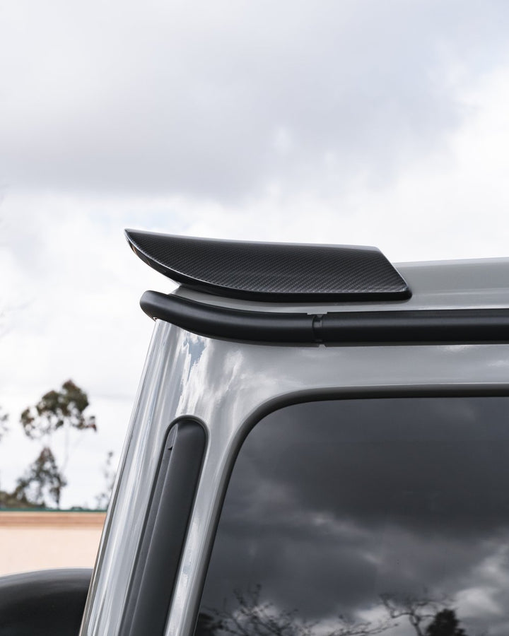 Urban Automotive carbon fiber rear upper spoiler for Mercedes-AMG G63 (W463), featuring high-gloss forged weave and direct OEM-fit installation (2019+)."