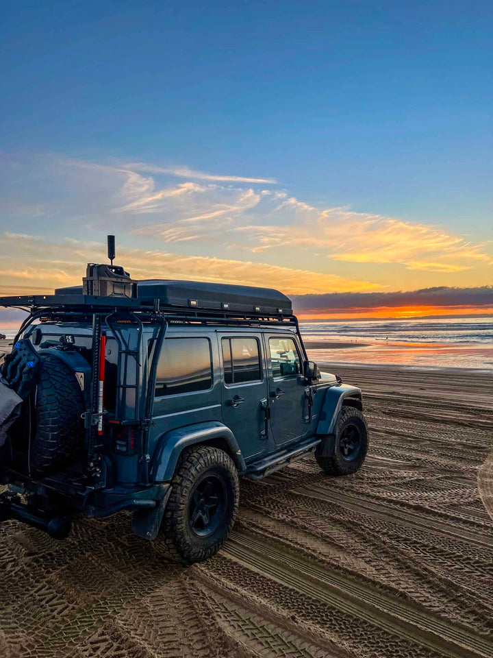 "iKamper Skycamp 3.0 deployed on a 4x4 with GOBI Rack, showcasing panoramic windows and stargaze panel under a mountain sunset.