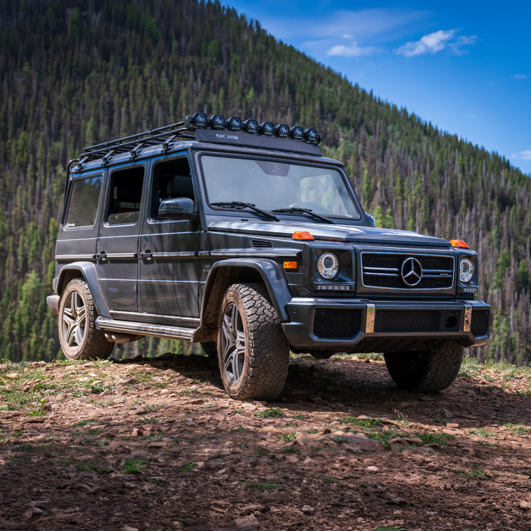 GOBI Stealth Rack installed on Mercedes G-Wagon (no sunroof), showcasing low-profile design and integrated lightbar mounts front right view of g wagon in the forest 