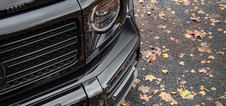Textured carbon fiber surface of Urban Automotive front splitter for G63 AMG, showcasing precision OEM-style design.