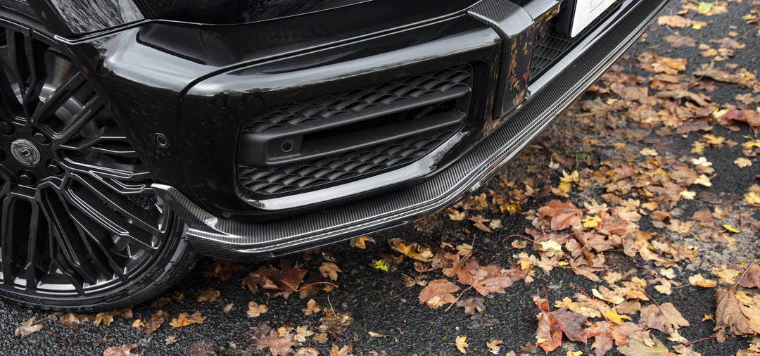 Urban Automotive carbon fiber front splitter mounted on Mercedes-AMG G63 bumper, enhancing aggressive aerodynamic styling.