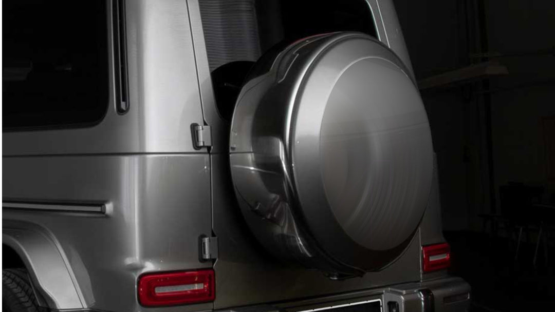 DMC carbon fiber spare wheel ring for Mercedes-Benz G-Class W463A/W464 (2015-2025) with high-gloss 3K weave finish installed on a grey G-Wagon