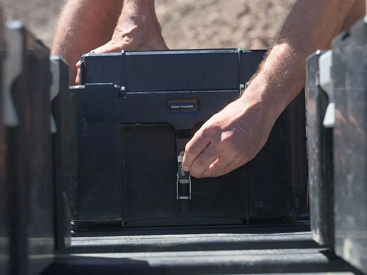 Side view of Front Runner Wolf Pack Pro Rack Mounting Bracket / MKII locking a storage box firmly on an overland vehicle roof rack.