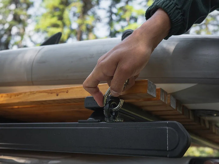 Black Tie Down Rings securing a storage case to the side rail of a Front Runner Rack for rattle-free travel