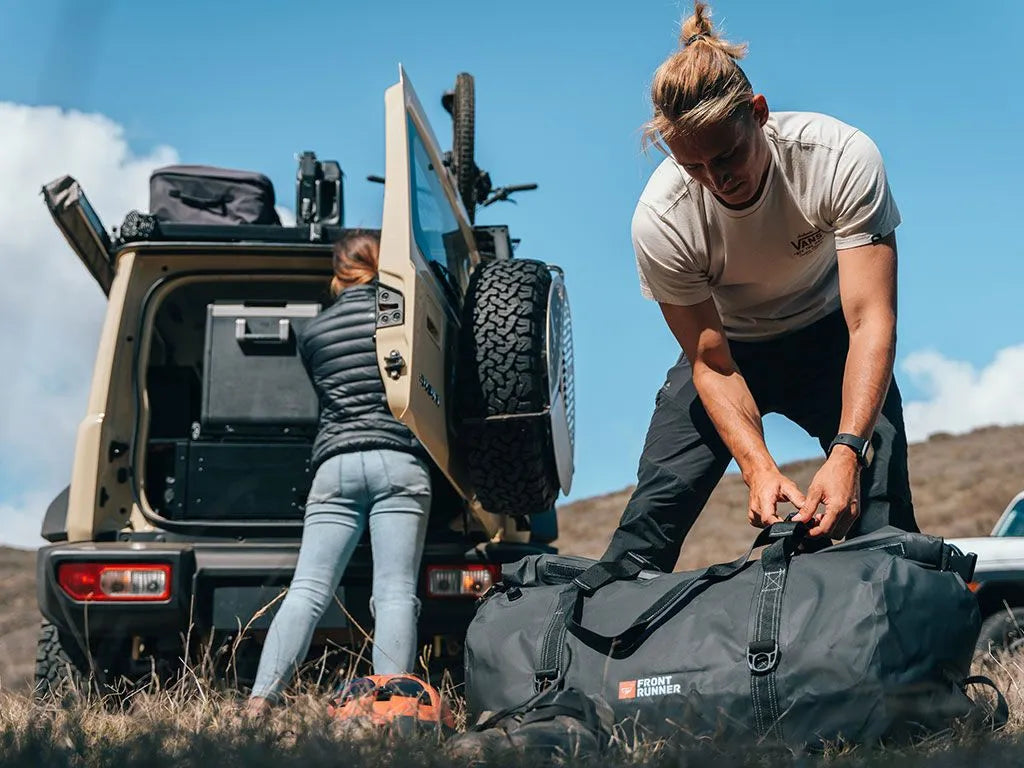 Typhoon Bag packed with clothes and outdoor equipment, illustrating versatile storage for travel and adventure.