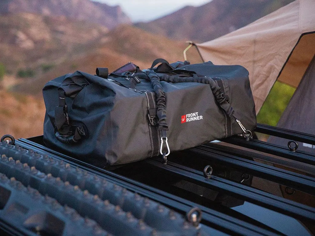 Front Runner Typhoon Bag mounted on a roof rack, showcasing its 100% waterproof and dustproof roll-top design.