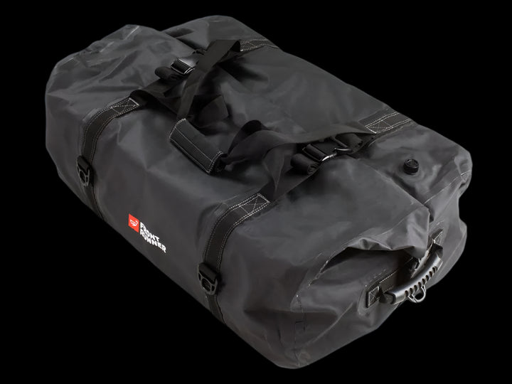 Black Typhoon Bag secured with Stratchits to a vehicle roof rack, keeping camping equipment dry and clean.