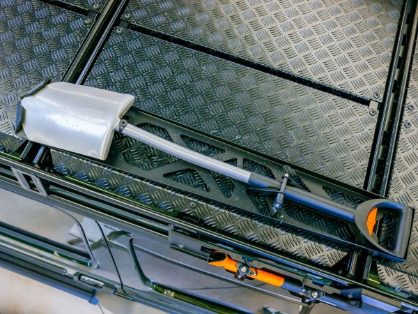 BRABUS Shovel Holder mounted on a roof rack, securely holding a Fiskars Telescopic Shovel