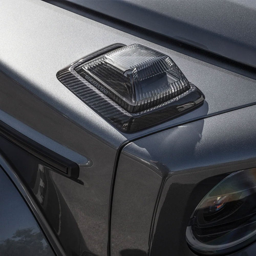 Close-up of the Urban Automotive carbon fiber indicator surrounds, highlighting the high-quality carbon fiber weave and precision fitment